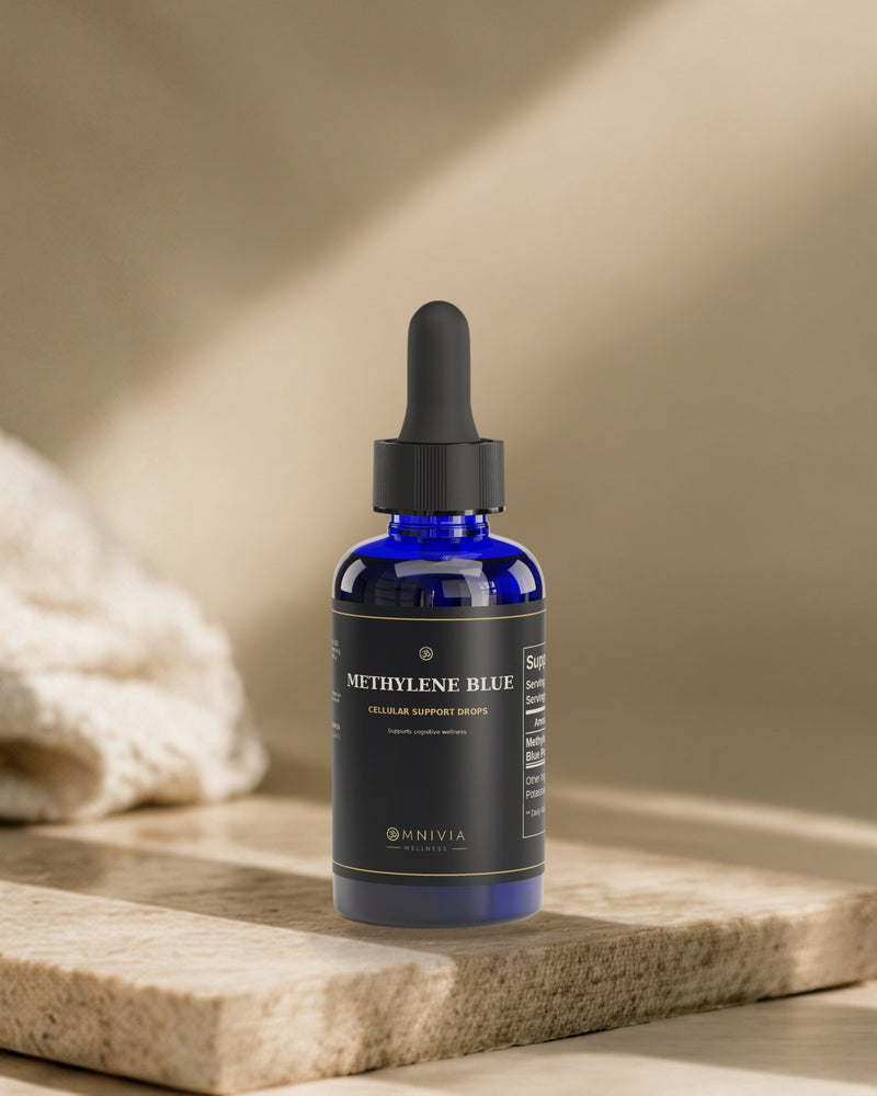 Omnivia Methylene Blue cobalt dropper bottle standing on a travertine slab in warm directional light