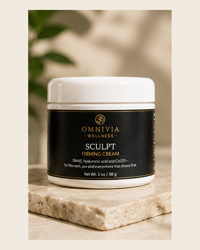 Sculpt Firming Cream in a white jar with a black and gold Omnivia Wellness label on a travertine slab