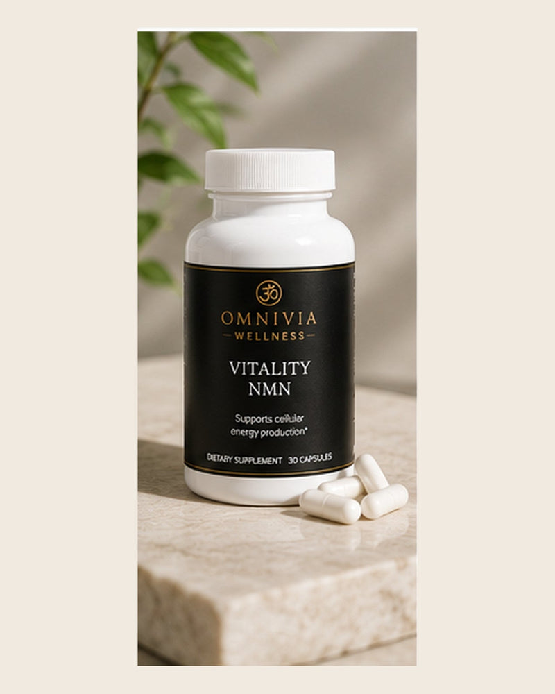 Vitality NMN capsule bottle with a black and gold Omnivia Wellness label, capsules resting on marble beside it