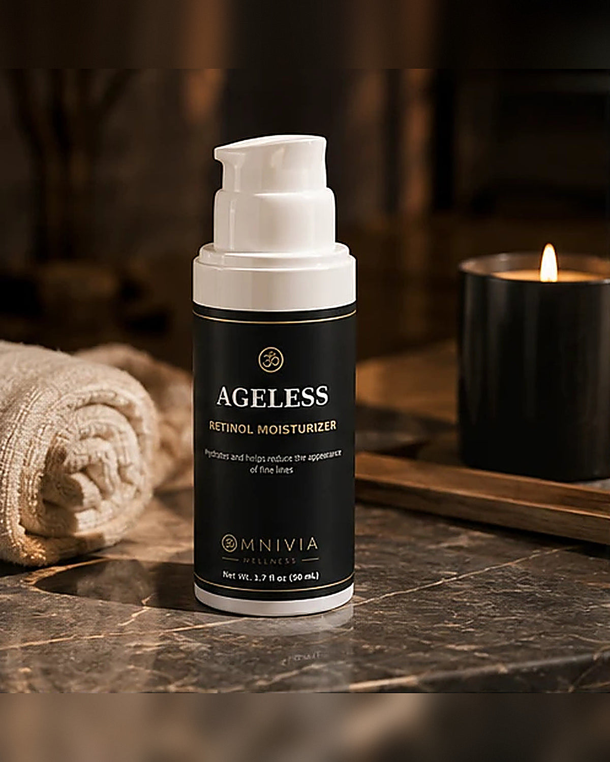 Ageless Retinol Moisturizer on dark marble with a lit candle and rolled towel in warm evening light