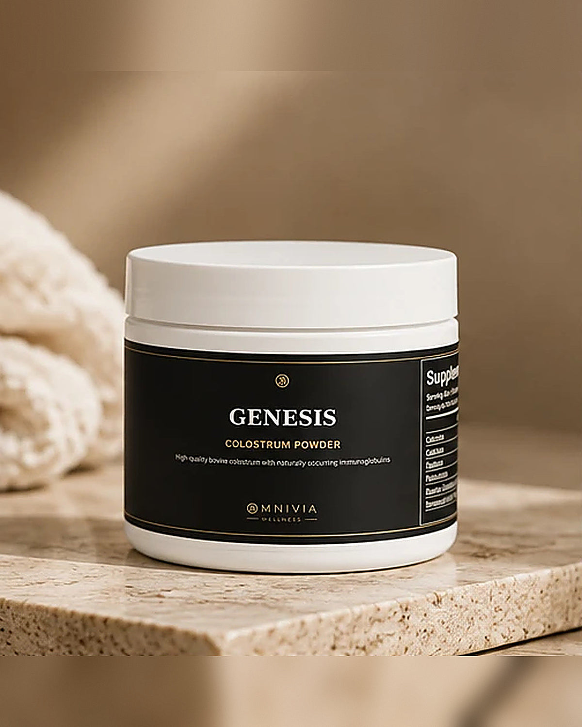 Genesis Colostrum tub on a travertine slab beside a soft towel in warm light