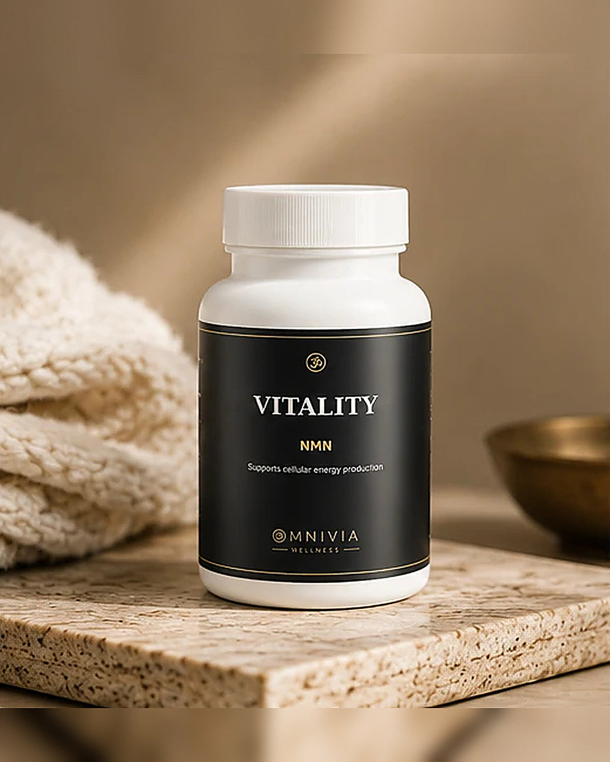 Vitality NMN bottle on a travertine slab beside a knit towel and brass bowl